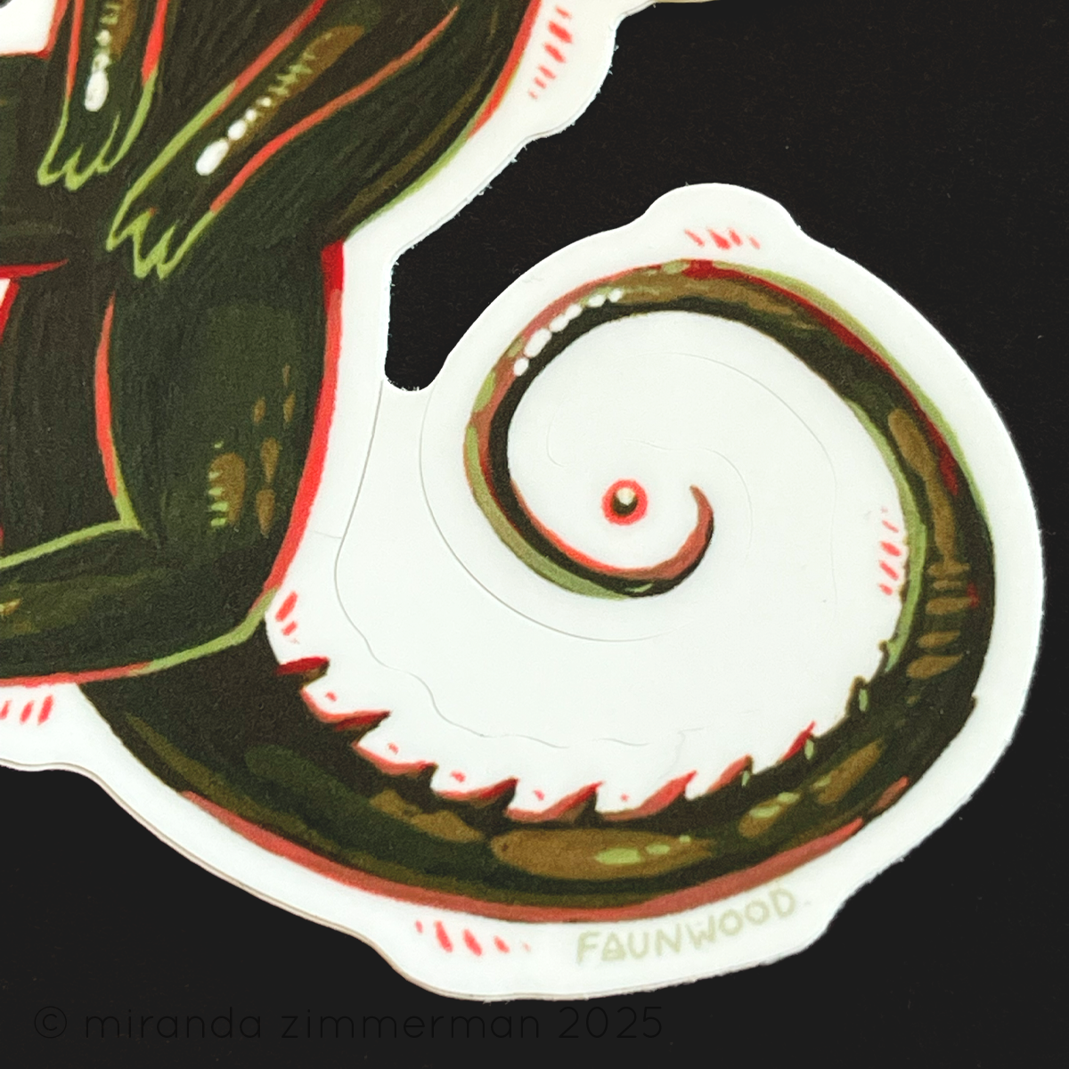 A close up of the tail of the lizard, showing the kiss cut in the sticker.