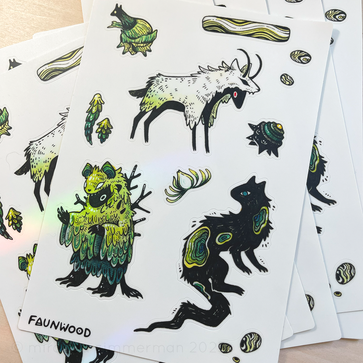Several matte vinyl sticker sheets depicting illustrated objects and creatures with the common theme of "layers". Designs include an onion creature, a creature draped in layers of feathers, and more. This listing is for a single sheet, even though more sheets are shown in this photo.