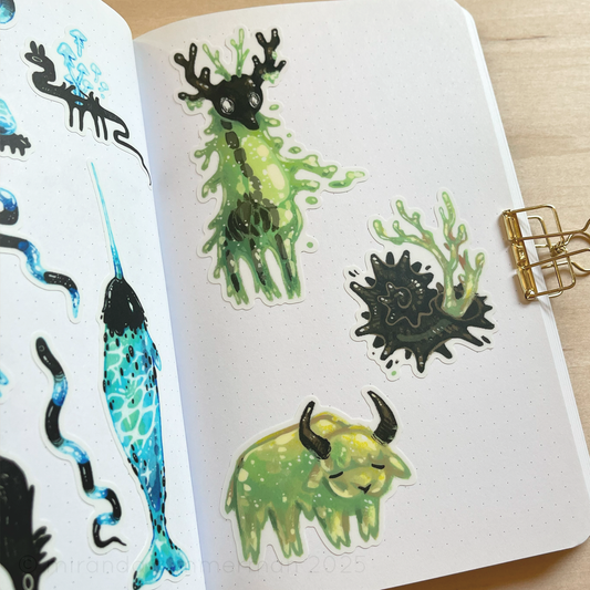 A photo showing the individual stickers removed from the sticker sheet and placed in a notebook, to showcase how they look individually.