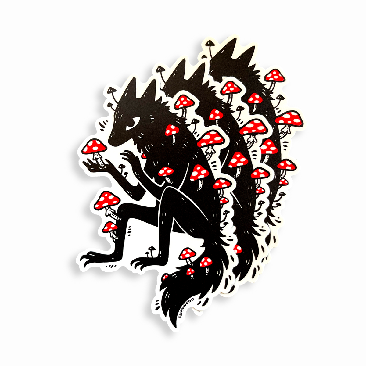 Three matte vinyl sticker featuring a black illustration of a wolfy fox covered in red amanita mushrooms.  The listing is for one single sticker, even though three are pictured here.