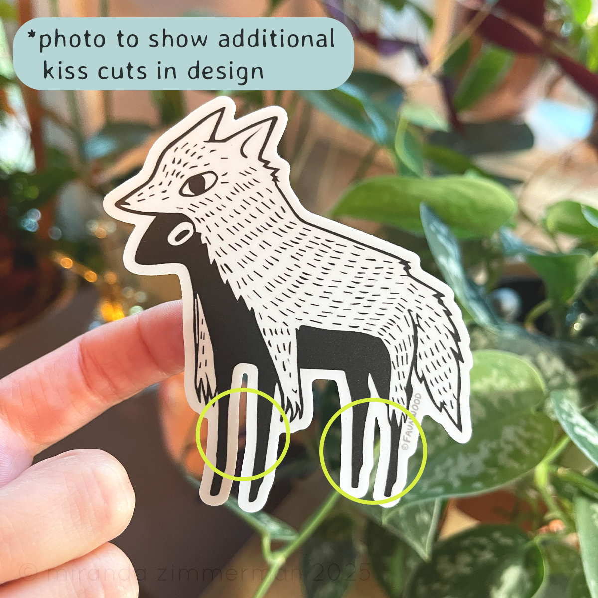 Hand holding a matte vinyl sticker of a stylized and illustrated "sheep in wolves clothing".  Photo is depicting the extra kiss cut areas between the legs.