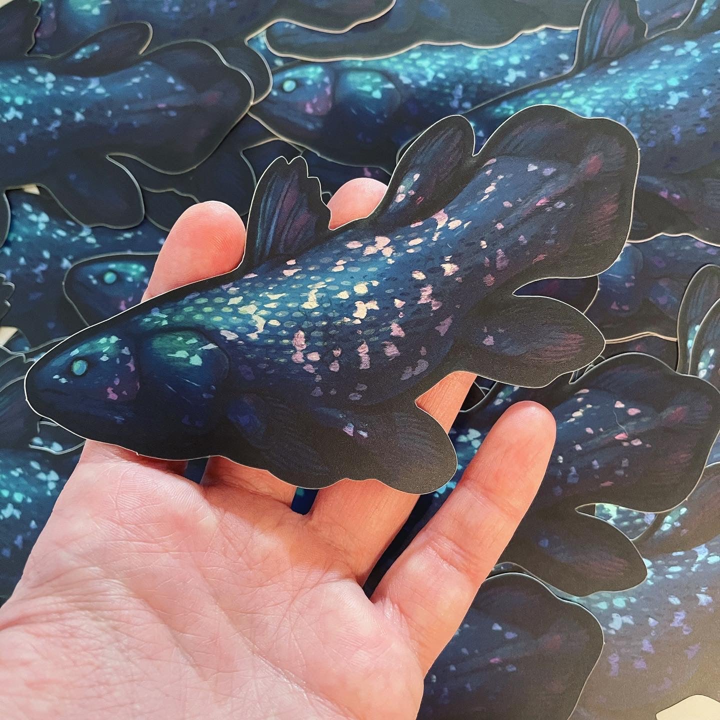 Dark blue and black coelacanth sticker with matte holographic elements.
